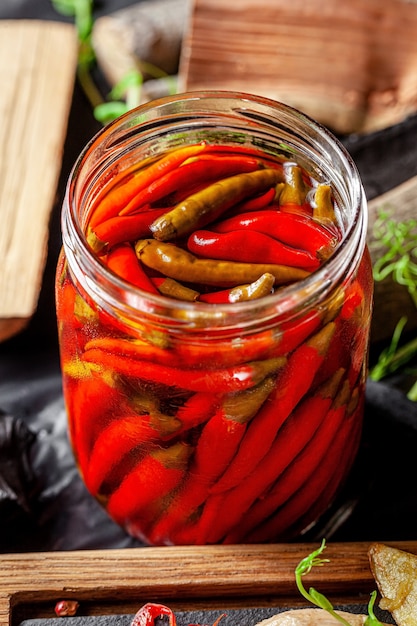 Close up on pickled red chili peppers in jar