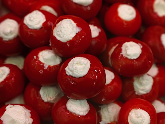 Close up decapato rovente peperoncini italiani rotondi ripieni di formaggio bianco fresco sul display al dettaglio, ad alto angolo di visione