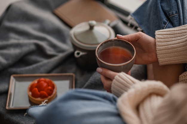 Close up picture of a girl having tea while sitting on the floor