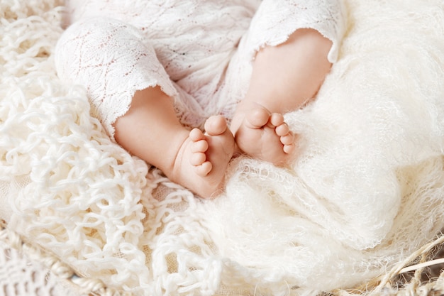 Close up picture of newborn baby feet in knitted plaid