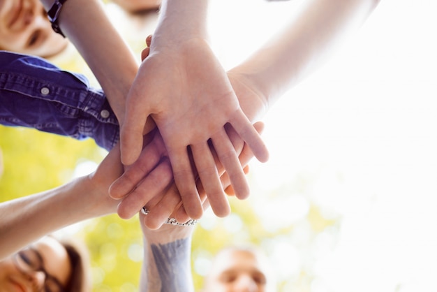 Foto chiuda sull'immagine delle mani della gente messe insieme. simbolo di lavoro di squadra e unità per raggiungere un determinato obiettivo