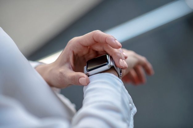 Chiudere l immagine delle mani di una donna che toccano uno smartwatch