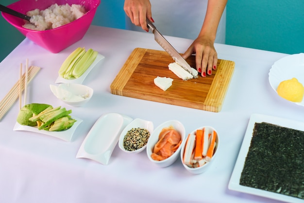 Close up picture of young lady's hands slicing cream cheese