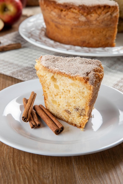 Close up piece of sponge cake or chiffon cake with apples so soft and delicious sliced with ingredients cinnamon eggs flour apples on wooden table Home bakery concept for background and wallpaper