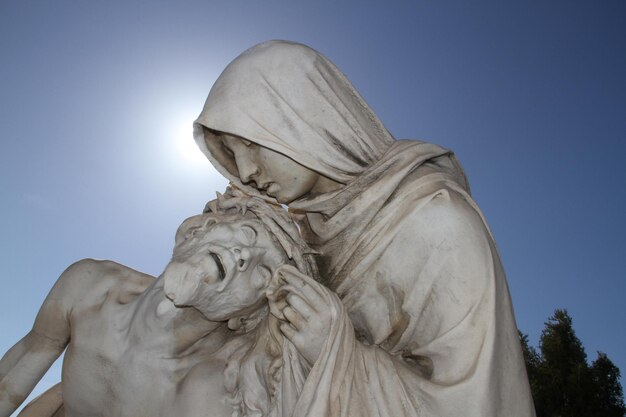 Close-up of pieta statue against clear blue sky