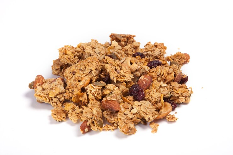 Photo close up pile granola isolated on white background.