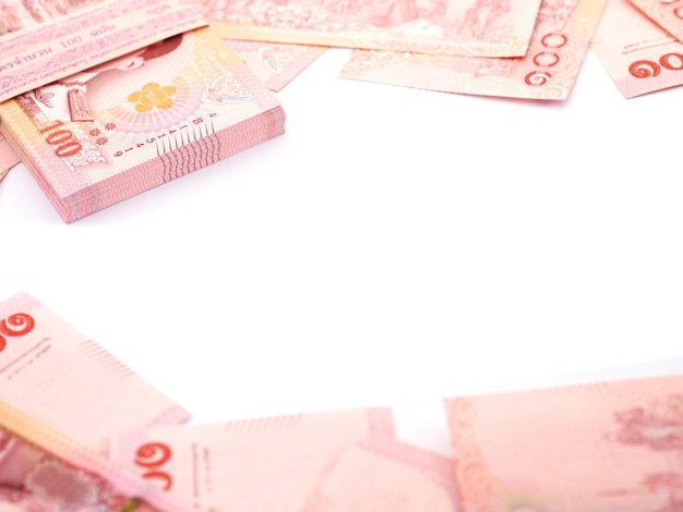 Close up pile of Thai 100 baht banknotes on white background, top view.