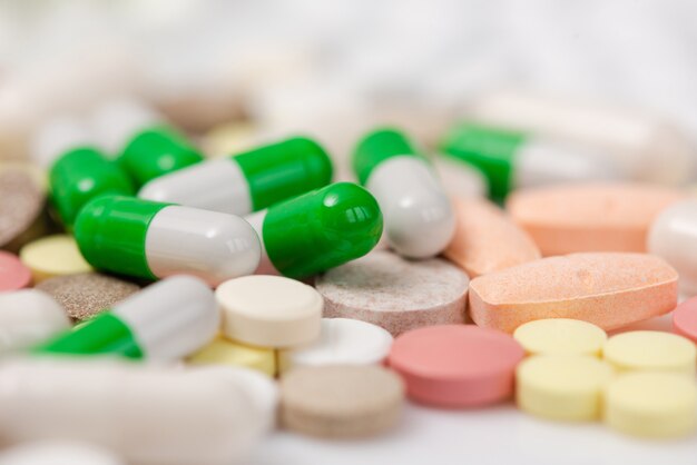 Close-up. Pile of yellow, white, green tablets.