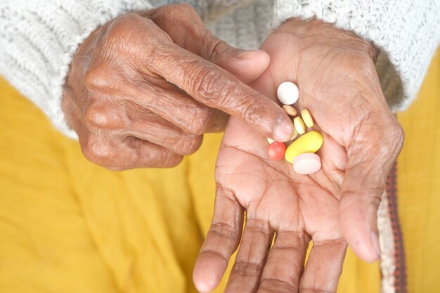 Close up of pills and capsule on senior womens hand