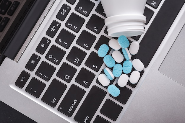 Photo close up of pills on a laptop, healthy and hard work concept. selective focus