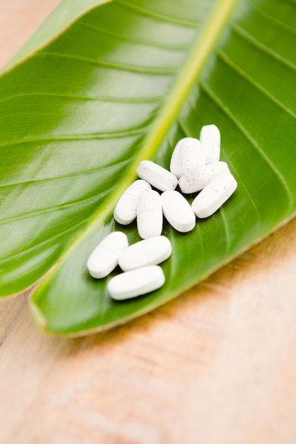 Close-up of pills on leaf at table