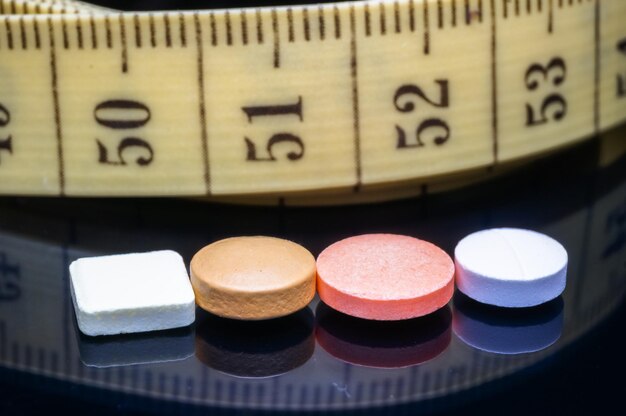 Close-up of pills and tape measure on table