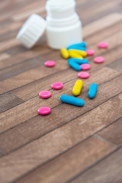 Photo close-up of pills on wooden floor