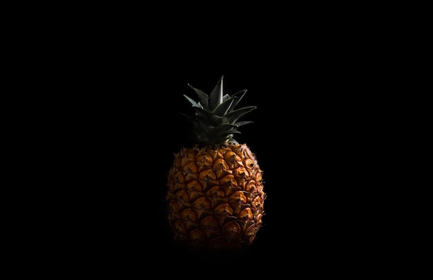 Photo close-up of pineapple against black background