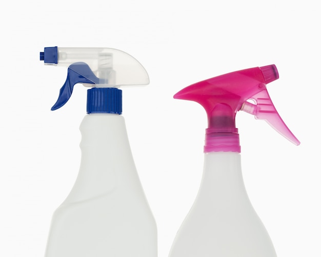 Photo close up of a pink and a blue spray bottles