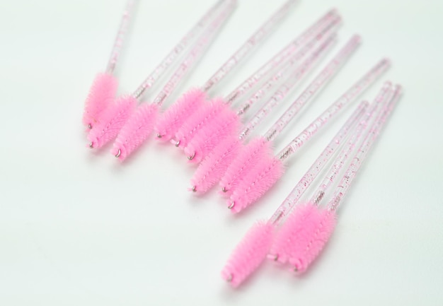 Close up of pink brushes for combing eyelash extensions and browstool for treatment