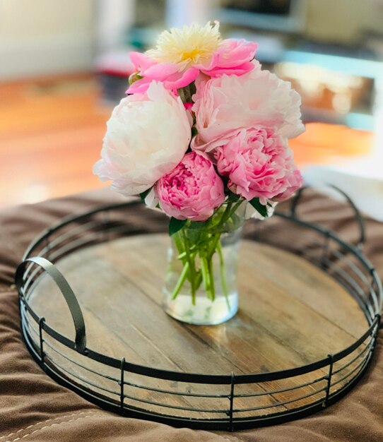 Foto close-up di un vaso di fiori rosa sul tavolo