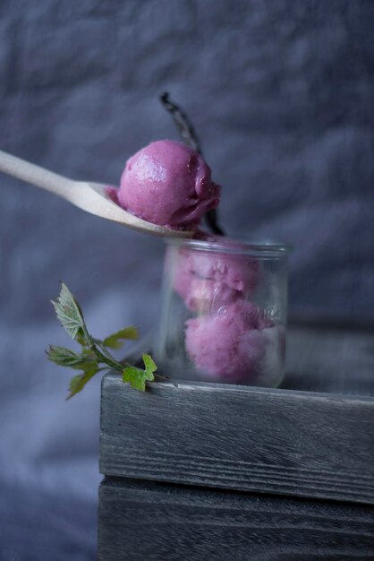 Photo close-up of pink fruit ice cream on table