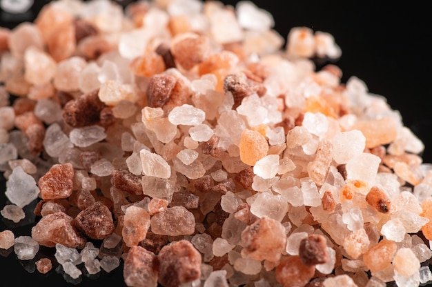 Close up of pink himalayan coarse salt on a black background,