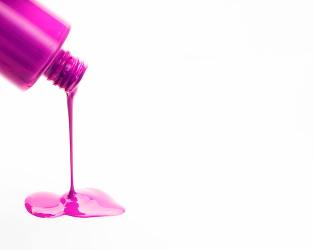 Close-up of pink nail polish spilling out from bottles