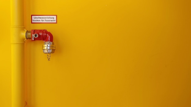 Photo close-up of pipe against yellow wall