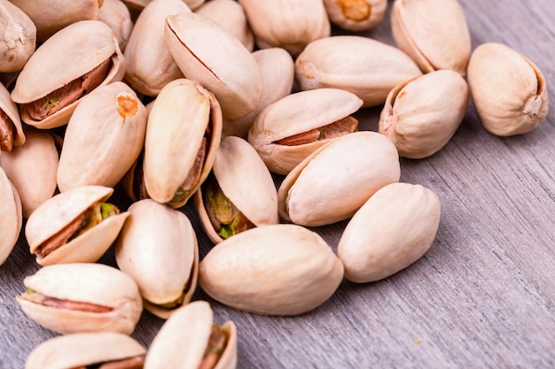 Close up pistachios nuts on wooden table.