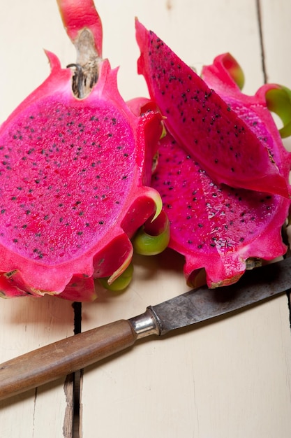 Foto close-up di fette di pitaya e coltello sul tavolo