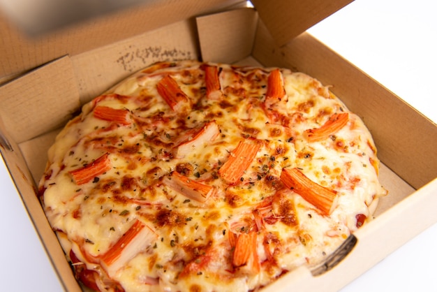 Close up of a Pizza in a cardboard box against on white background
Pizza delivery. Pizza menu.