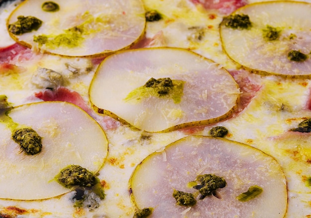 Close-up pizza met perenkaas en ham.