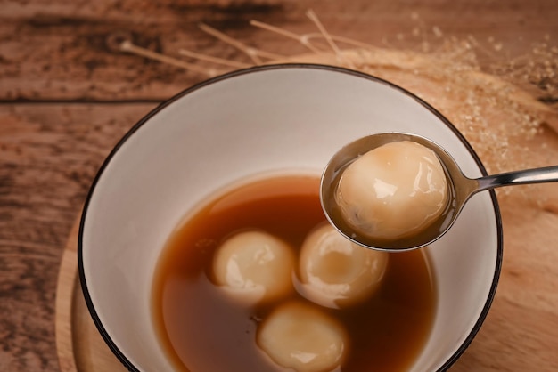 Close-up plakkerige rijstballen met zoete gembersoep op houten tafel.