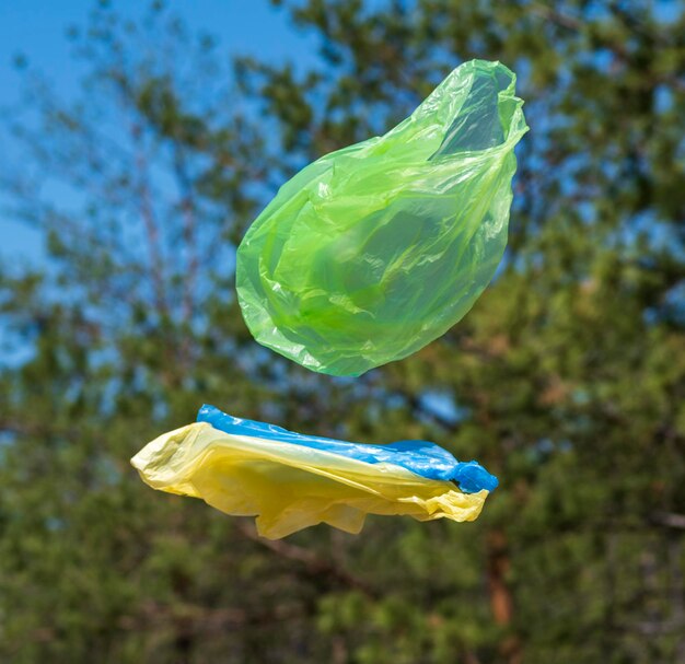 close-up of plastic bags in mid-air against trees