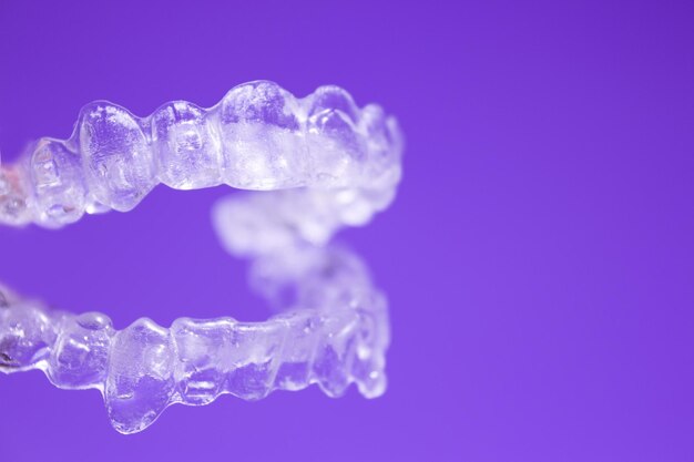 Close-up of plastic braces against purple background