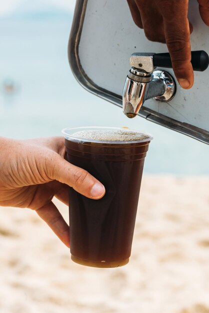 Photo close up of a plastic cup being filled with mate a fresh brazilian tea