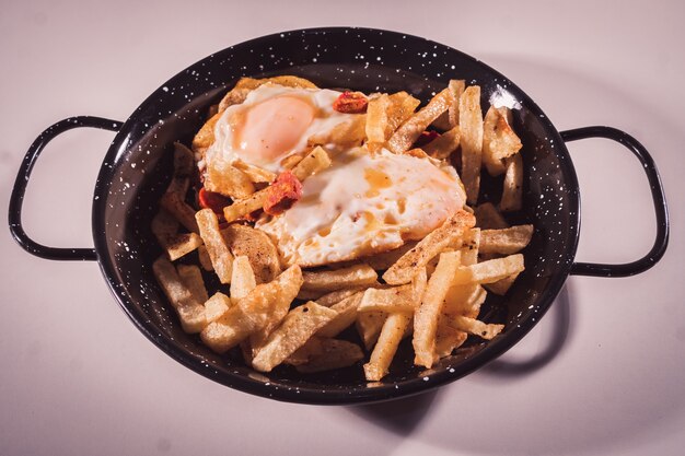 Close up of a plate of scrambled eggs or eggs with chorizo and chips selective focus