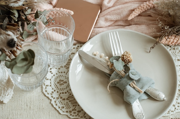 Close up of a plate with cutlery, decorated with dry flowers in a rustic style.