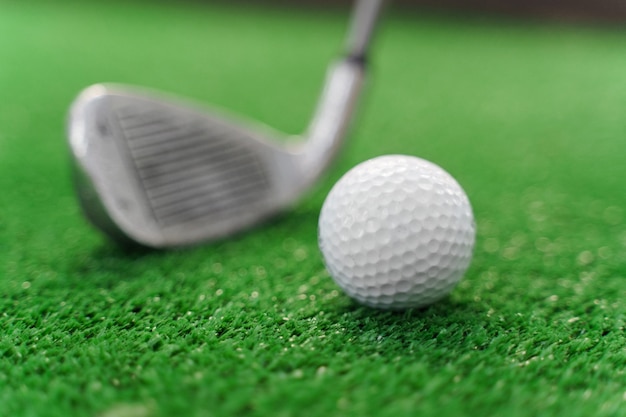 Close-up playing in mini-golf on the green grass using niblick