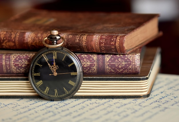 close-up of pocket watch and book on table