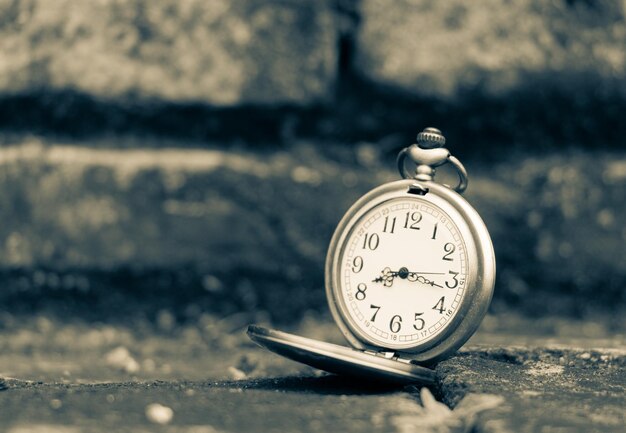 Photo close-up of pocket watch on footpath