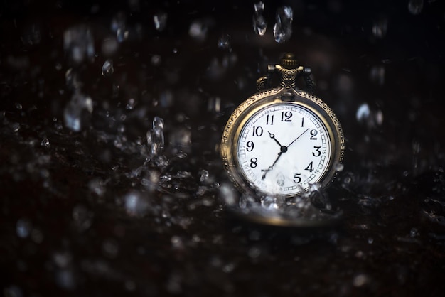 Photo close-up of pocket watch on water