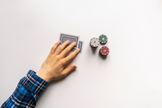 A close up poker player holding a playing card on the table win\
or loose simple concept