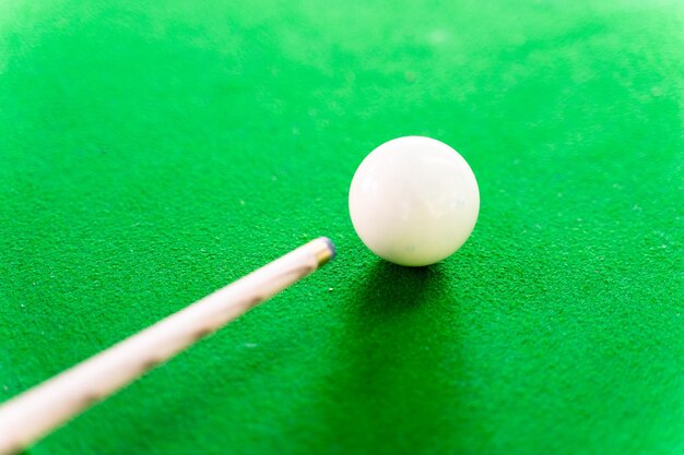 Photo close-up of pool cue by ball on table