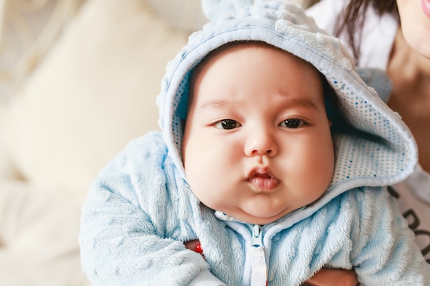 Close-up portrait of 2 month old newborn mixed race Asian Caucasian boy. Natural indoor lighting. Cool tones