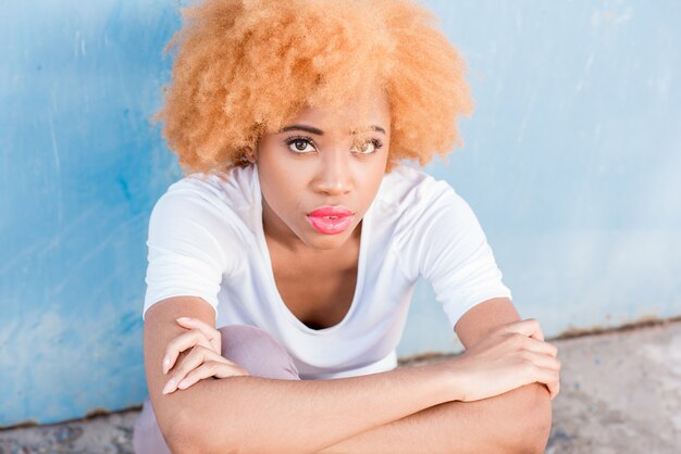 Close-up portrait of an african woman on the blue wall background