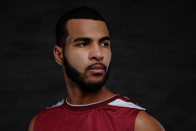 close-up portrait of an afro-american basketball player. isolated over dark background.
