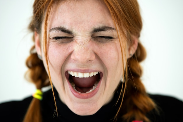 Photo close up portrait of angry redhead teenage girl.