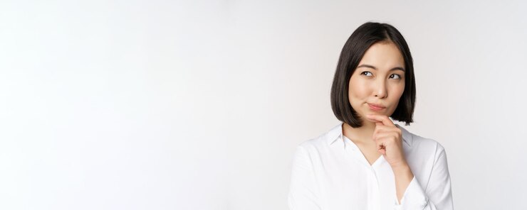 Photo 脇を見て考え、立っている意思決定を熟考しているアジアの女性の肖像画をクローズアップ