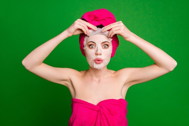 Close-up portrait of attractive funky lady wearing turban removing ugly snail essence facial mask pout lips isolated on bright green color background