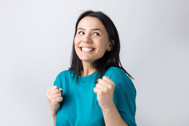 Close up portrait of attractive shouting in winning smiling with raised fists young she her girl wearing jeans shirt clothes isolated on grey background