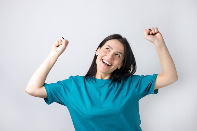 Close up portrait of attractive shouting in winning smiling with raised fists young she her girl wearing jeans shirt clothes isolated on grey background