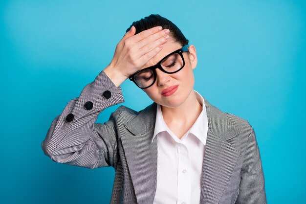 Close-up portrait of attractive sick depressed tired lady feeling bad touching forehead isolated over bright blue color background